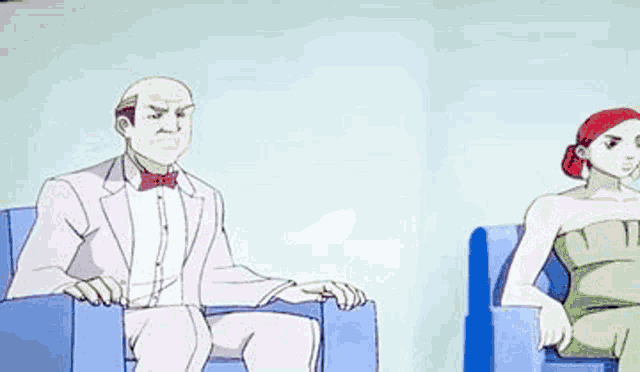 a man is falling on his back while a woman sits in a chair next to him .