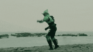 a man in a shark costume is running on a beach