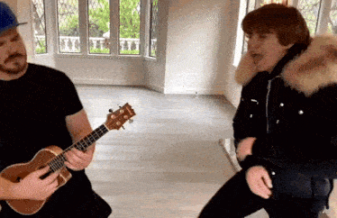 a man is playing an ukulele and a woman is dancing