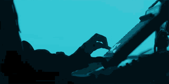 a person is playing a keyboard with a blue sky in the background