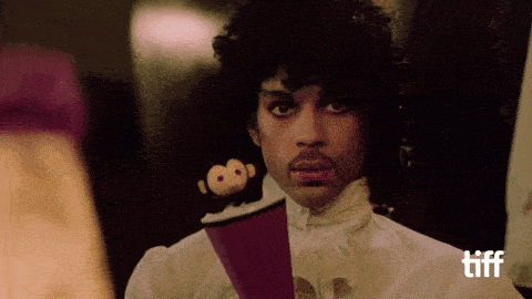 a man in a white shirt holds a stuffed monkey on a purple object