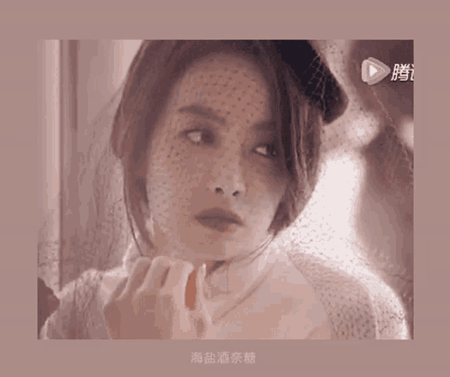 a woman with a veil on her face has chinese writing on the bottom