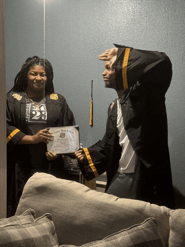 a man in a graduation cap and gown is holding a certificate
