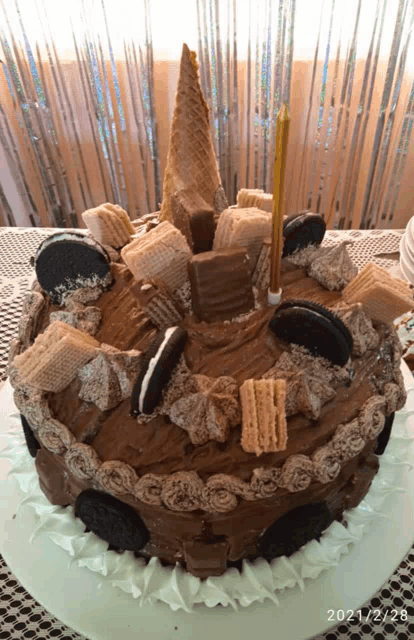 a cake with a candle on top of it and the date 2021/2/28 on the bottom