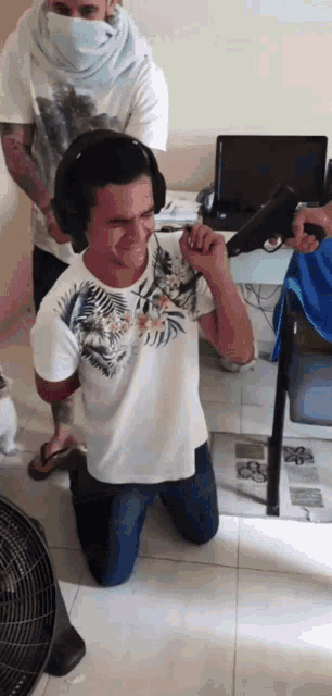 a man wearing headphones is kneeling down with a gun