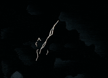 an aerial view of a building with a few windows lit up at night