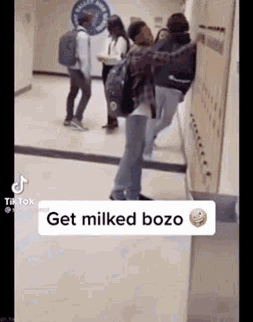a group of people are standing next to each other in a hallway in a school .