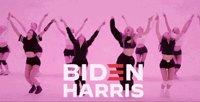 a group of women are dancing in front of a biden harris poster