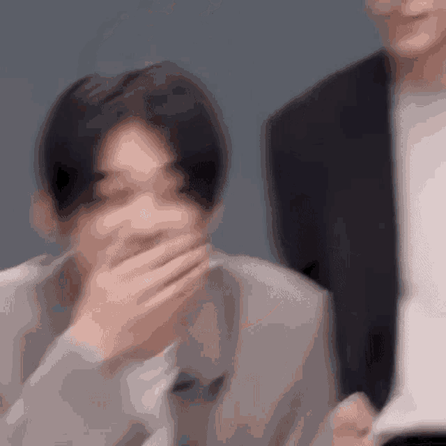 a blurry picture of a man in a suit laughing .