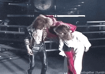 a man and a woman are dancing on a stage in front of a drum set .
