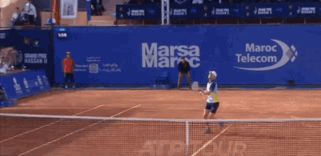 a tennis player is playing in front of a wall that says marsa maroc