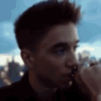 a close up of a man 's face with a blue sky in the background .