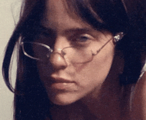 a close up of a woman 's face wearing glasses and headphones