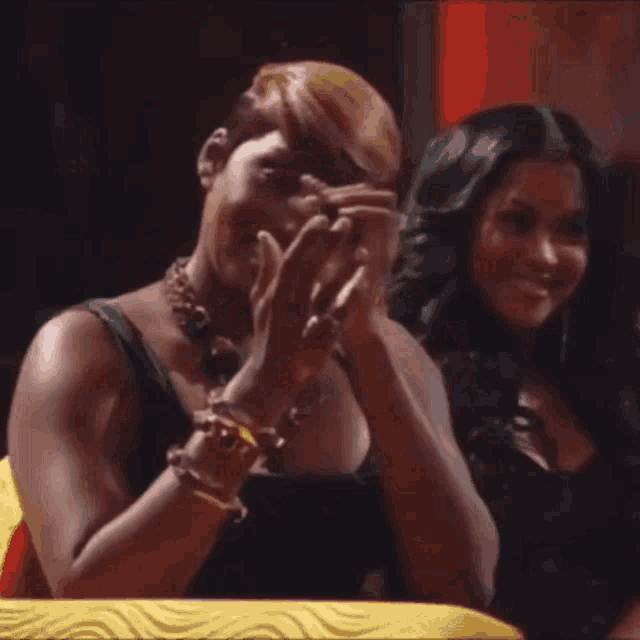 two women are sitting next to each other on a couch and smiling