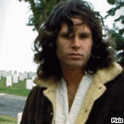 a man with long hair is standing in front of a cemetery with pixiz written in the corner
