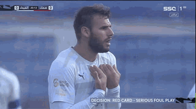 a soccer player stands in front of a screen that says serious foul play