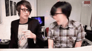 two men are sitting next to each other in front of a screen that says channel