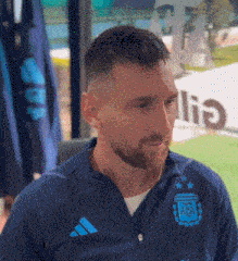 a man with a beard wearing an adidas jacket