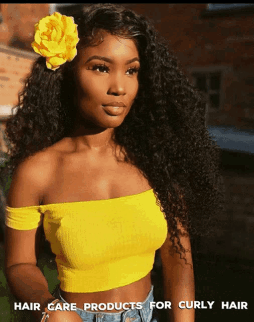 a woman wearing a yellow off the shoulder top with a flower in her hair