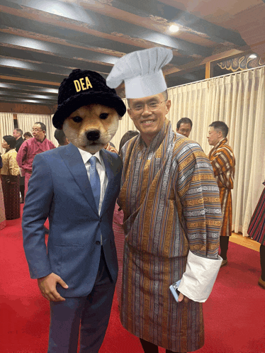 a man in a suit stands next to a dog wearing a dea hat