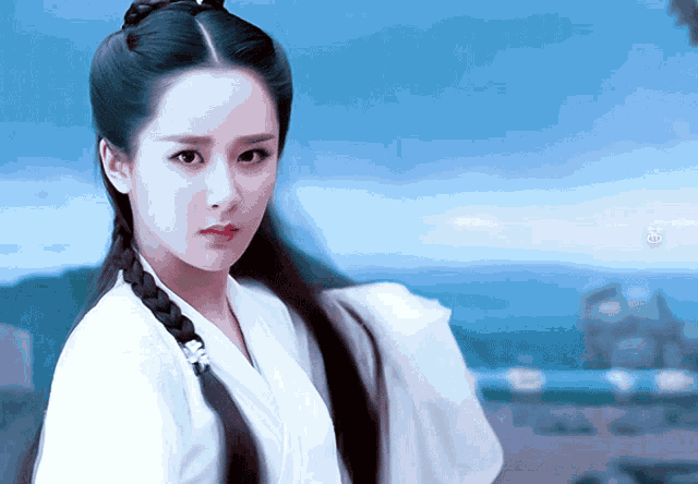 a woman with a braid in her hair is wearing a white shirt