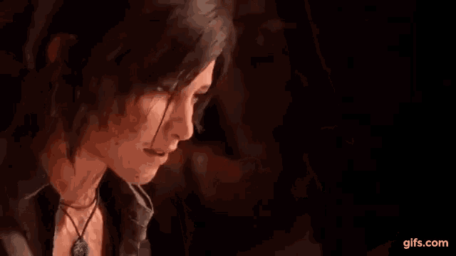 a close up of a woman in a video game with a necklace around her neck .