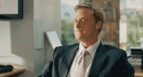 a man in a suit and tie is sitting in an office