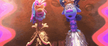 a couple of trolls are standing next to each other on a stage