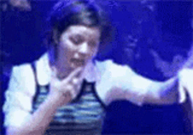 a blurry picture of a woman dancing in front of a microphone .