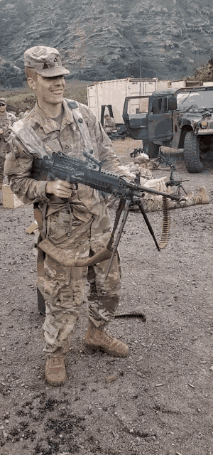 a man in a military uniform is holding a rifle