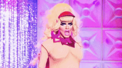 a drag queen is standing on a stage with her mouth open and wearing a hat and bow tie .