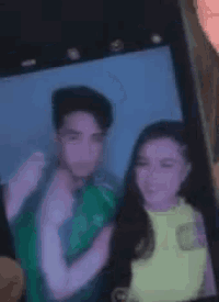 a man and a woman are taking a selfie on a cell phone .