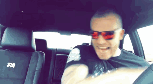 a man wearing sunglasses is sitting in the back seat of a dodge charger r