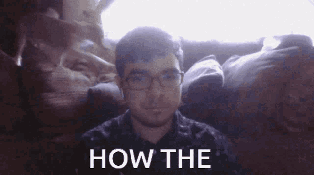 a man with glasses is sitting on a couch with the words how the written on the bottom