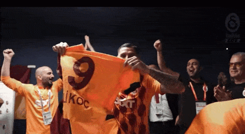 a man is holding up a flag with the number 9 on it