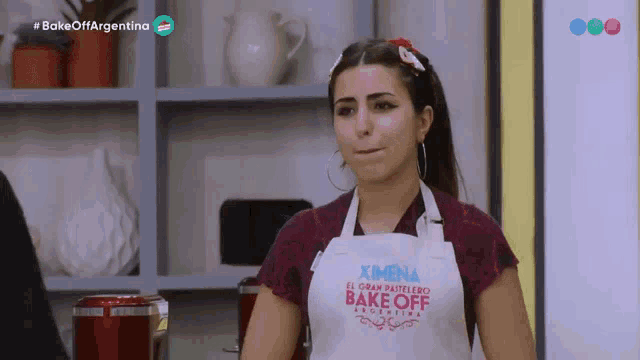 a woman wearing an apron that says bake off