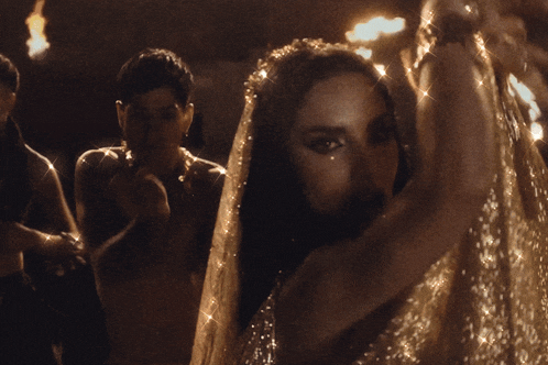 a woman with a veil on her head is dancing in a dark room