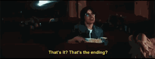 a man sitting in a theater watching a movie with the words that 's it that 's the ending