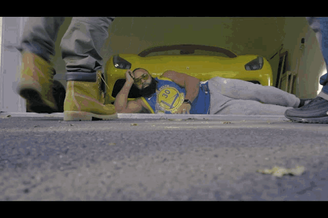 a man wearing a golden state warriors shirt lays on the ground