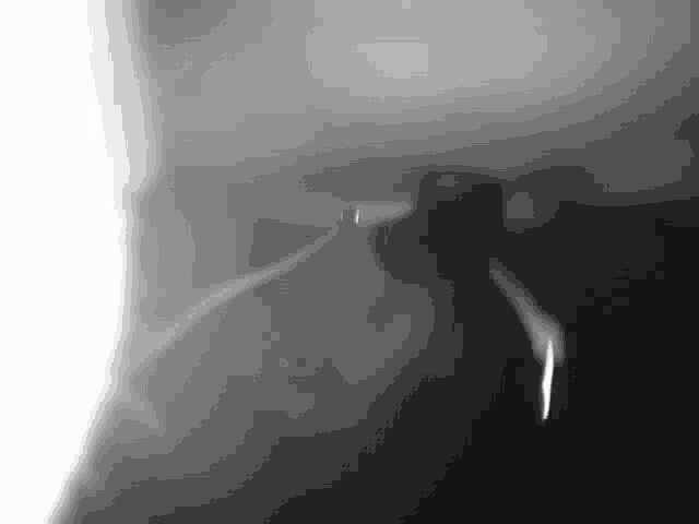 a black and white photo of a person holding a gun in a room .