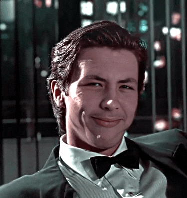 a young man in a tuxedo and bow tie smiles