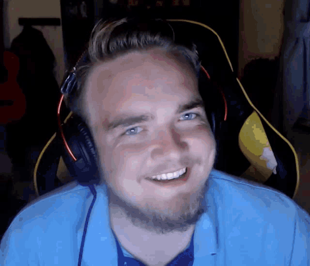 a man with a beard wearing headphones is smiling