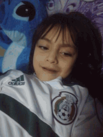 a young girl wearing a white adidas shirt