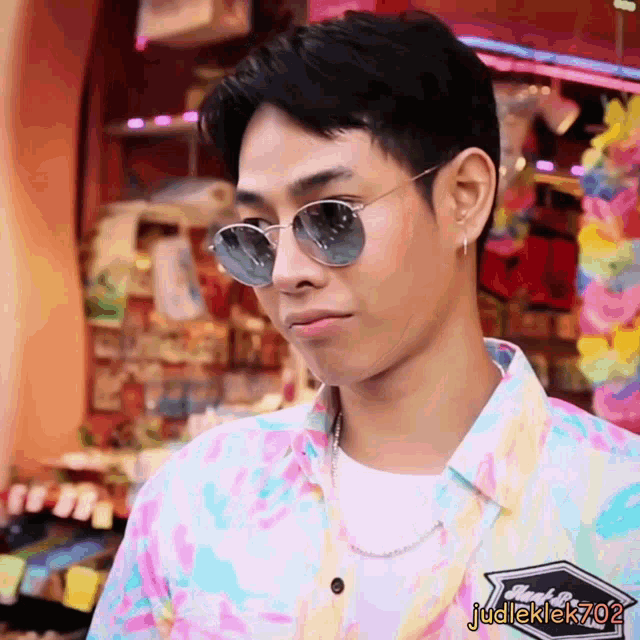 a man wearing sunglasses and a colorful shirt has the name judleklek702 on his shirt