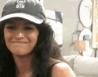 a woman wearing a black hat with the word otk on it