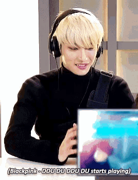 a man wearing headphones is sitting in front of a laptop with the words blackpink - ddu du ddu du starts playing