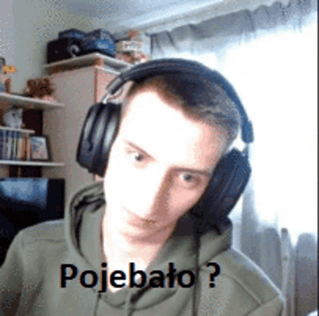 a young man wearing headphones and a green hoodie has the word pojebato written on his face
