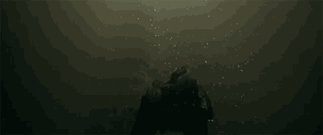 a person is swimming in the dark water with bubbles coming out of it