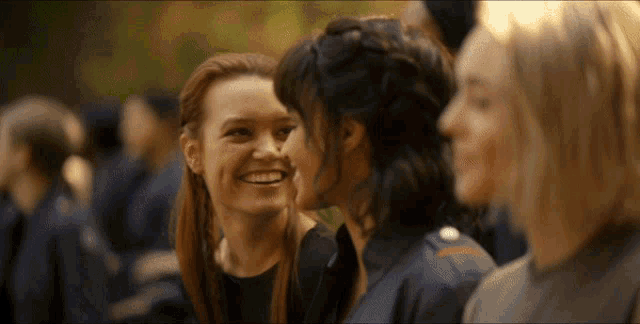 a group of women are smiling in a crowd
