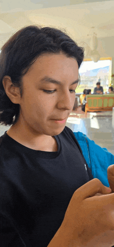 a young man wearing a black shirt is looking down